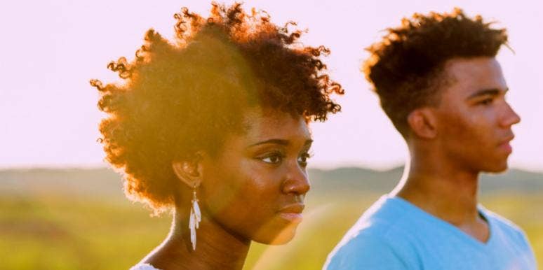 young black couple looks out at horizon, backlit by sunshine