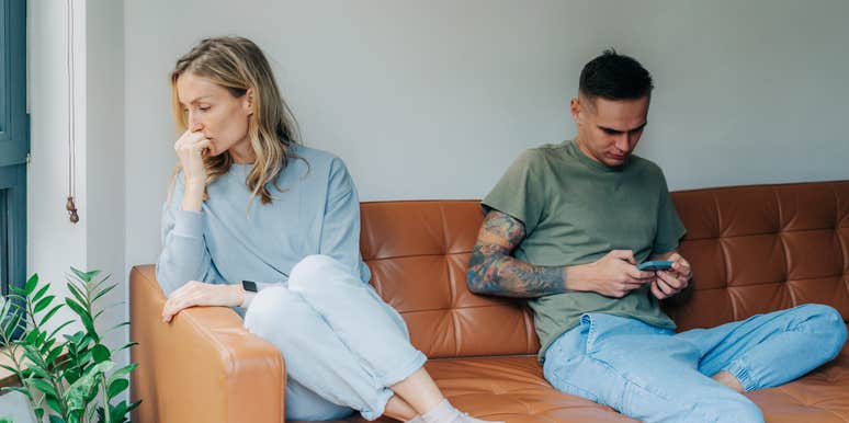 couple on couch disconnected because of technology