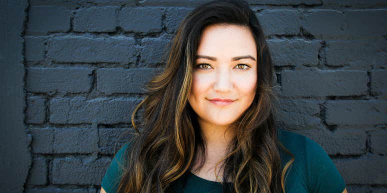 Woman Refuses To Drop Ex-Husband's Last Name After He & His Fiancé Claim It's 'Weird' She Still Has It Woman in front of black wall