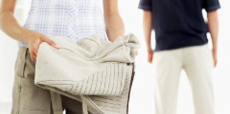 How To Show Your Love When He's Away Woman folding a sweater into luggage