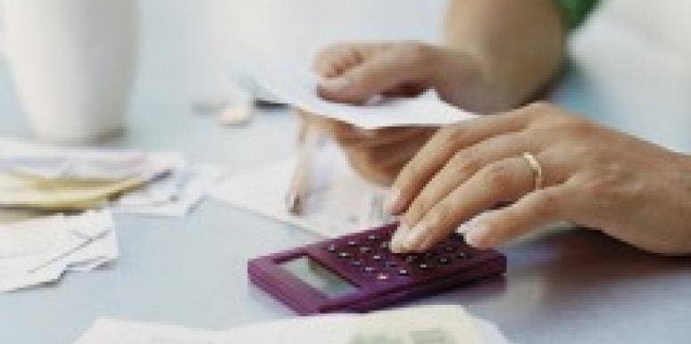 Calculating The Cost Of A Career Change Woman's hand using a calculator