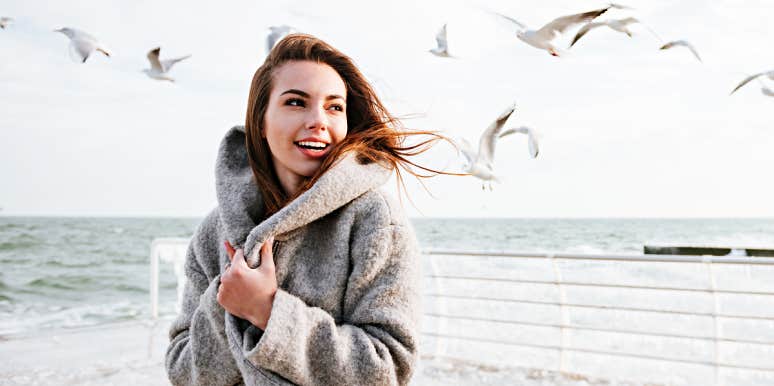Words to eliminate from vocabulary for peace joyful woman on a beach with birds flying behind her