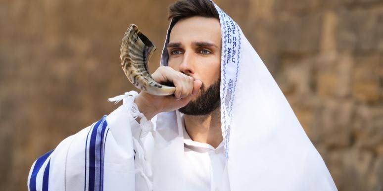 What Is Yom Kippur? Meaning, Fasting & Greetings man blowing the shofar on Yom Kippur