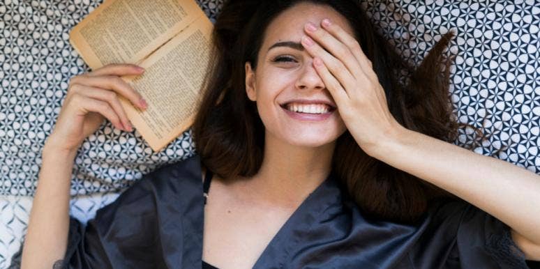 woman smiling reading a book