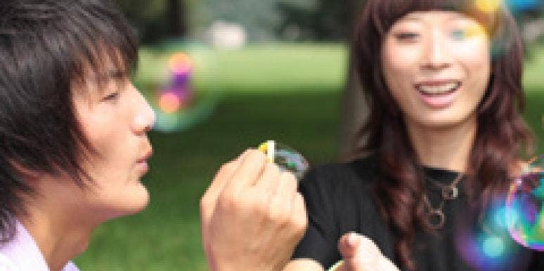 How To Date In The Present asian couple blowing bubbles outside