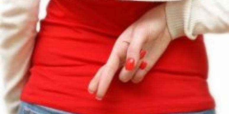 Infidelity 101: What Is An Emotional Affair? woman fingers crossed behind her back