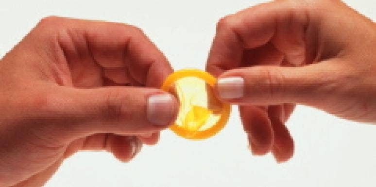 My Year of Condomless Sex woman holding yellow condom