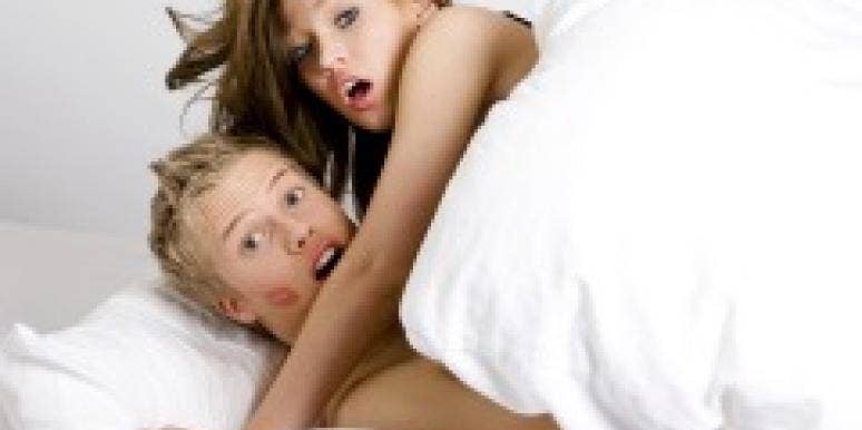 Surprised couple caught in bed together