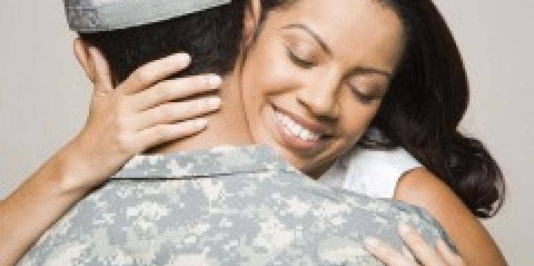 Woman embracing man in fatigues