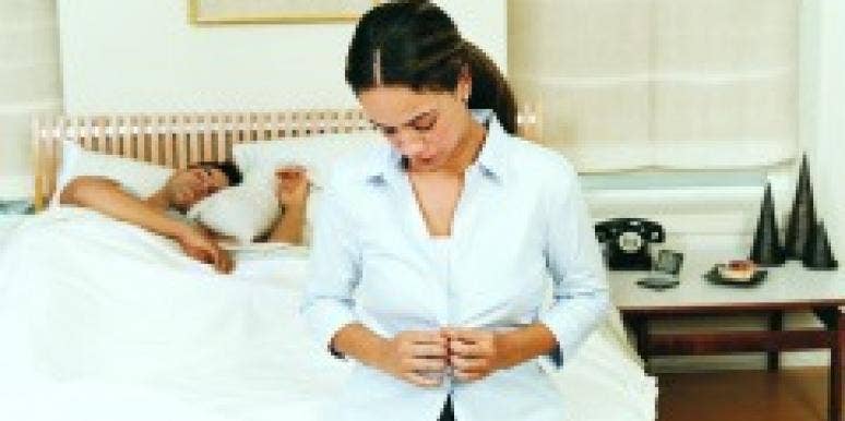 8 Ways To Avoid One-Night Stand Awkwardness Woman geting dressed while man sleeps