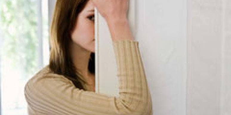 How To Answer Pesky Questions About Your Love Life woman hiding behind a door frame
