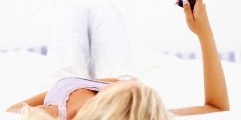 woman lying on bed with cell phone