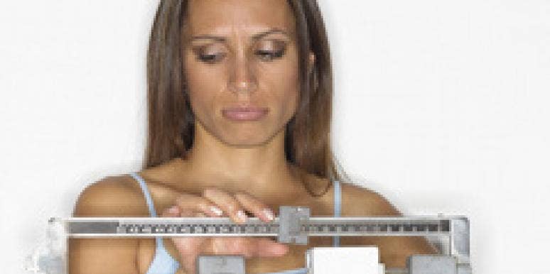 Woman taking weight on scale.