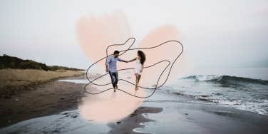 Couple spontaneously running down the beach