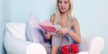 Blonde woman reading card to accompany gift
