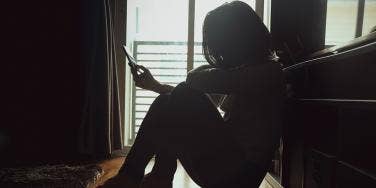 woman sitting in the dark