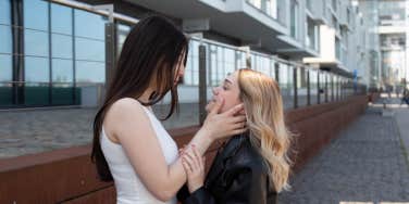 one woman holding another woman's face 