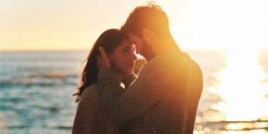 romantic couple hugging at sunset near beach