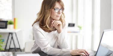 woman on computer in white top