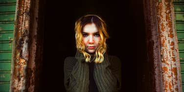 dramatic woman standing in dark alley