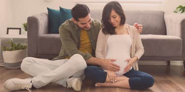 man touching the stomach of a pregnant woman