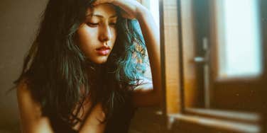 Bizarre thing that causes all break ups, woman with hand on forehead looking down