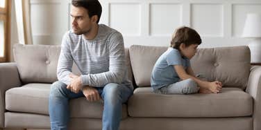 upset father and son sitting on couch