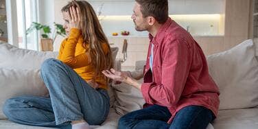 Couple arguing on couch and one partner not listening.