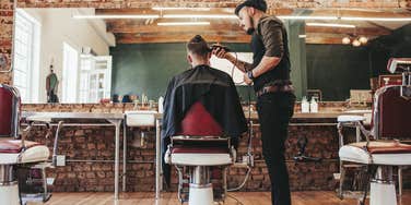 barber cutting man's hair in barber shop