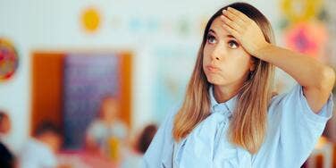 Upset teacher blowing out air in classroom