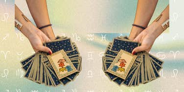 hand holding tarot cards for horoscope reading may 30