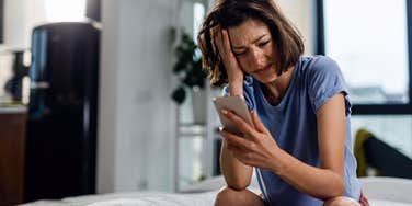 crying teen checks phone after upsetting news