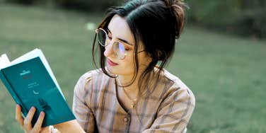 Woman reading outside, managing her Post-Traumatic Stress Disorder, healing with spirituality. 
