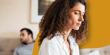 Woman sitting on edge of bed debating if he will commit, hoping to avoid heartbreak