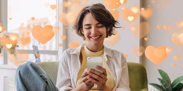 Woman with short brown hair smiling at the text message that means the most to her