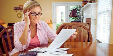 woman sitting at table paying monthly bills