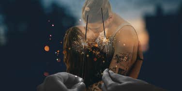 Sensual couple in relationship kissing during fireworks