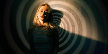Woman leaning against wall feeling herself spiral into shame, Stopping feeling ashamed