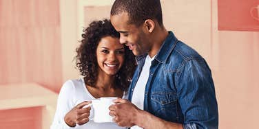 A woman cuddling her man, drinking coffee, figuring out what he truly needs