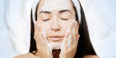 Woman cleanses her skin as she cleanse her toxic ex from her life and feels refreshed.