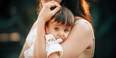 Mother holding her son who inherited the same cancer syndrome as her.