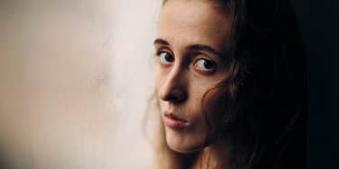 Somber adult woman, realizing her parents don't love her.