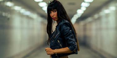 Portrait of Fashionable woman in stylish clothing walking down cross street tunnel