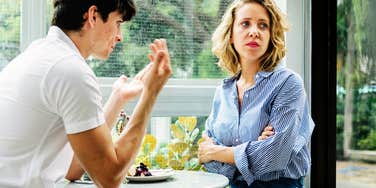 Frustrated woman sitting in front of husband.