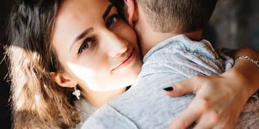 Wife encouraging her husband to be more emotionally vulnerable with a hug.