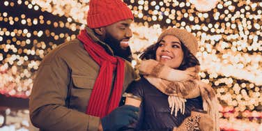 Couple enjoying drama-free winter holidays in front of lights