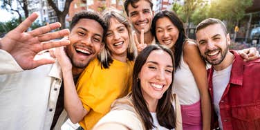 group of millennial friends smiling at camera