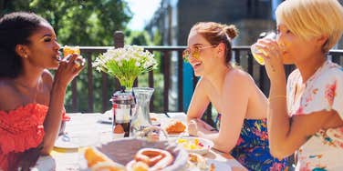 Woman gossiping with her girlfriends over brunch.