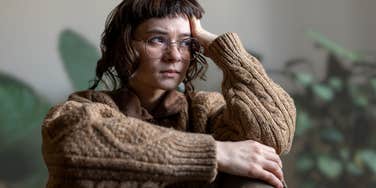 Stressed woman holding her head while sitting