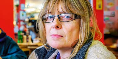 Somber baby-boomer woman looking directly at camera. 